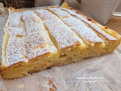 a cake sitting on top of a table covered in powdered sugar