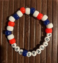 a red, white and blue beaded bracelet with words made out of glass beads