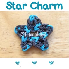 the star charm is made out of blue and gray crocheted yarn on a wooden table