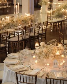 the tables are set up with white linens and centerpieces for an elegant wedding