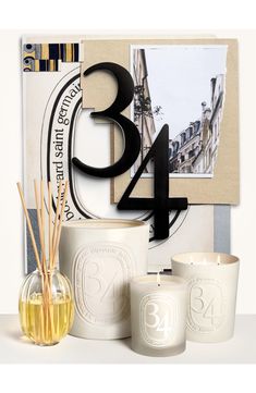 an assortment of candles are displayed in front of the number 34 sign and other items