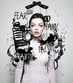 a woman is standing in front of a wall with words all over her face and clock above her head