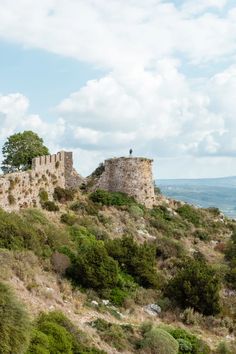 an old stone castle sitting on top of a hill