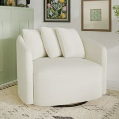 a living room with a white chair and pictures on the wall