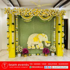 an elephant decorated with yellow flowers and greenery