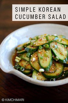 a white bowl filled with sliced cucumbers on top of a wooden table