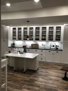 a large kitchen with white cabinets and wood flooring is pictured in this image from the doorway