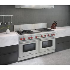 a stove top oven sitting inside of a kitchen next to a counter with utensils on it