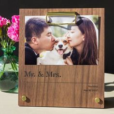 a wooden photo frame with a couple kissing and holding a dog in front of them