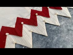 four red and white chevroned fabric with pearls on them, sitting next to each other