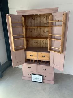 a pink cabinet with wooden shelves and drawers