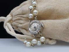 This bracelet style watch has 28 Pearls strung in 14k white gold. The watch face has 25 small white diamonds that encircle it. The watch is not only beautiful, but it is in remarkable condition and working. Made in around 1910 with a manual winding action, this timepiece will add beauty to the everyday task of telling time. The watch manufacturer Dreyfus Frères & Co. opened a luxury sister company in 1903 in Péry, Switzerland and called it simply 'Pery'. Unfortunately the Péry watch company did Platinum Wedding Watch, Round, Wedding Platinum Watches, Round Shape, Platinum Diamond Watch For Wedding, Platinum Wedding Watch, Platinum Diamond Wedding Watch, Wedding Platinum Watches, Luxury Diamond Watch With Jubilee Bracelet, Timeless Round Diamond Watch For Weddings, White Gold Diamond Watch