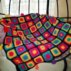 a crocheted blanket is sitting on a chair