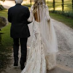 a man and woman walking down a dirt road