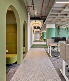 an empty office with chairs and desks lined up along the corridor between two walls