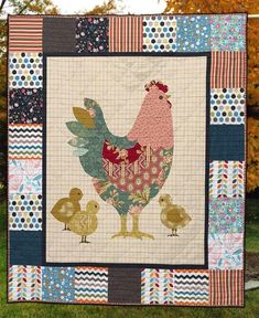 a quilted wall hanging on the side of a house with chickens and roosters