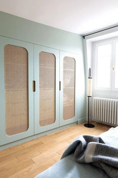 a bedroom with blue walls and wooden flooring next to a white radiator