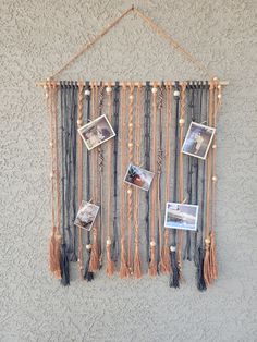 a wall hanging with pictures and tassels on it