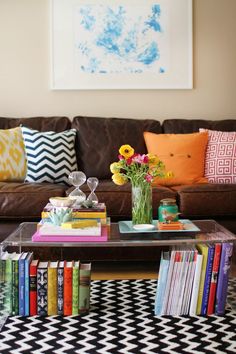 a living room with a couch, coffee table and bookshelves on the floor