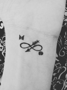 a black and white photo of a wrist tattoo with an infinite symbol on the side