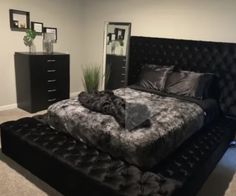 a bedroom with a bed, dressers and mirror in it's center area