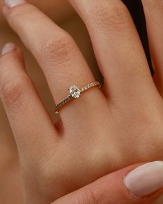 a woman's hand with a diamond ring on top of her finger and an engagement band