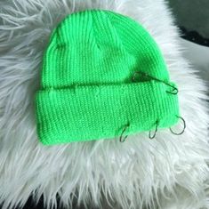 a green beanie hat sitting on top of a white furry animal's fur