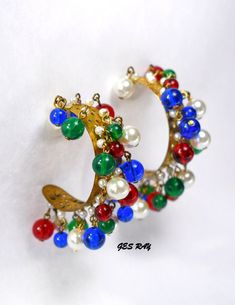 "This Vintage Miriam Haskell pre-WWII era Frank Hess Runway Blue, Green, Red Gripoix Glass and Faux Pearl (wired into brass panel) and all beads dangles on swags of brass panel pierced huge hoop earrings is a spectacular creation. The earrings measures 2.5\" x 1.5\" x 0.5\". Attributed early unsigned Miriam Haskell. Very elegant and colorful. Please see enlarged pictures for a detailed view. Please, contact us with any questions about the items we sell. Please, be attentive, before you buy any i Festive Multicolor Beaded Hoop Earrings, Red Hoop Jewelry For Festive Occasions, Festive Dangle Hoop Earrings With Beads, Festive Red Hoop Jewelry, Multicolor Festive Round Hoop Earrings, Vintage Multicolor Hoop Earrings, Vintage Multicolor Hoop Earrings As Gift, Festive Earrings With Colorful Beads, Festive Round Earrings With Colorful Beads