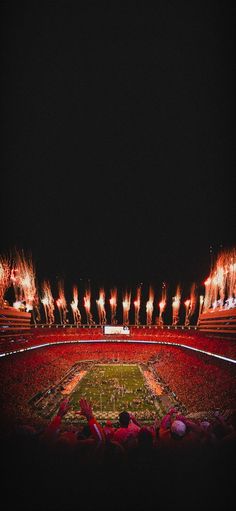 a stadium filled with lots of red and white firecrackers in the air