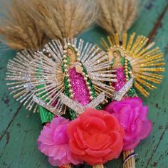 two flowers are sitting next to some fake grass and other decorations on a wooden table