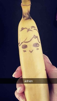 a person holding a banana with a drawing on it