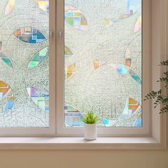 a potted plant sitting on top of a window sill next to two windows