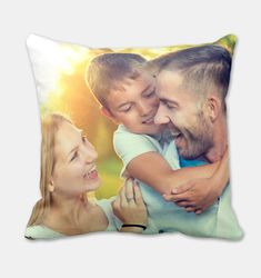 a pillow with an image of a man and woman holding a boy in his arms