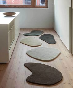 four rugs are arranged on the floor in front of an open window and sink