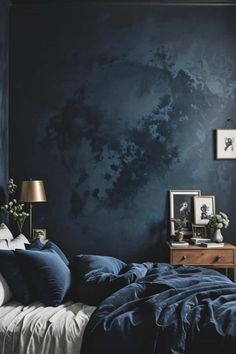 a bedroom with dark blue walls and white bedding