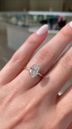 a woman's hand with a ring on it and a diamond in the middle