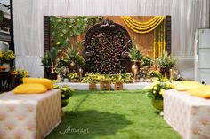 an outdoor ceremony setup with flowers and greenery on the wall, decorated in gold vases