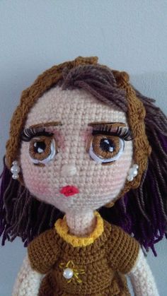 a crocheted doll with big eyes and brown hair