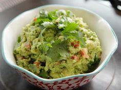 a bowl filled with guacamole and garnished with cilantro