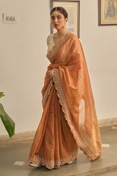 Rust saree with scallop trimmed, floral hand embroidery. Paired with a cream blouse with stripe pattern. - Aza Fashions Wedding Sharara With Embroidered Border In Cotton Silk, Cotton Silk Saree Blouse With Embroidered Border, Tissue Silk Dupatta With Embroidered Border For Reception, Reception Tissue Silk Saree With Embroidered Border, Fitted Tissue Silk Saree With Embroidered Border, Elegant Cotton Silk Blouse Piece With Embroidered Border, Designer Tissue Silk Pre-draped Saree With Embroidered Border, Fitted Chanderi Pre-draped Saree With Embroidered Border, Eid Saree Blouse With Embroidered Border