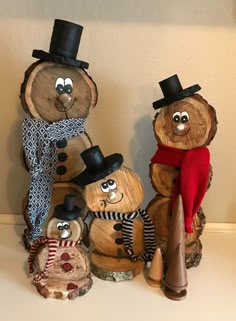 three wooden carved snowmen with hats and scarves