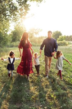 a family walking through the grass holding hands