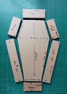 cardboard cut out to look like a car with measurements on the front and sides, sitting on top of a cutting board