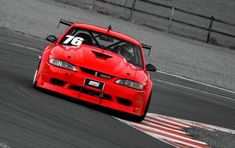 a red sports car driving on a race track