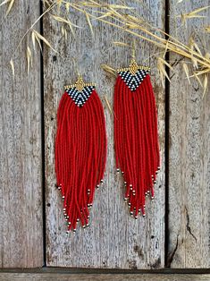 two pairs of red beaded earrings with black and white details