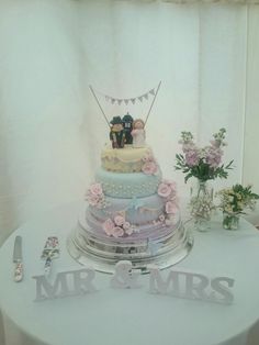 there is a wedding cake on top of the table with mr and mrs signs next to it