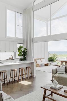 a living room filled with furniture and lots of windows next to a white counter top