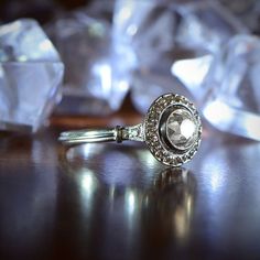 a diamond ring sitting on top of a table next to ice cubes and crystals