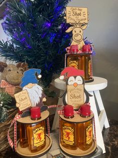 two bottles of honey sitting on top of a table next to a christmas tree and stuffed animals