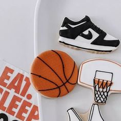 cookies decorated to look like basketballs and shoes are on a plate next to a pair of sneakers